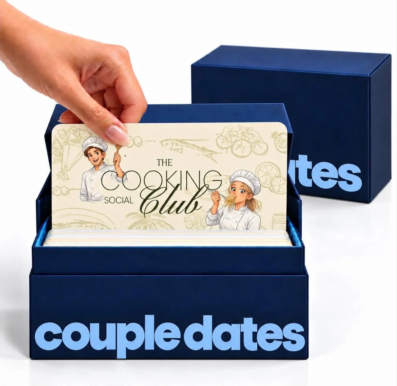 Mano sacando la tarjeta The Cooking Social Club de la caja de Couple Dates